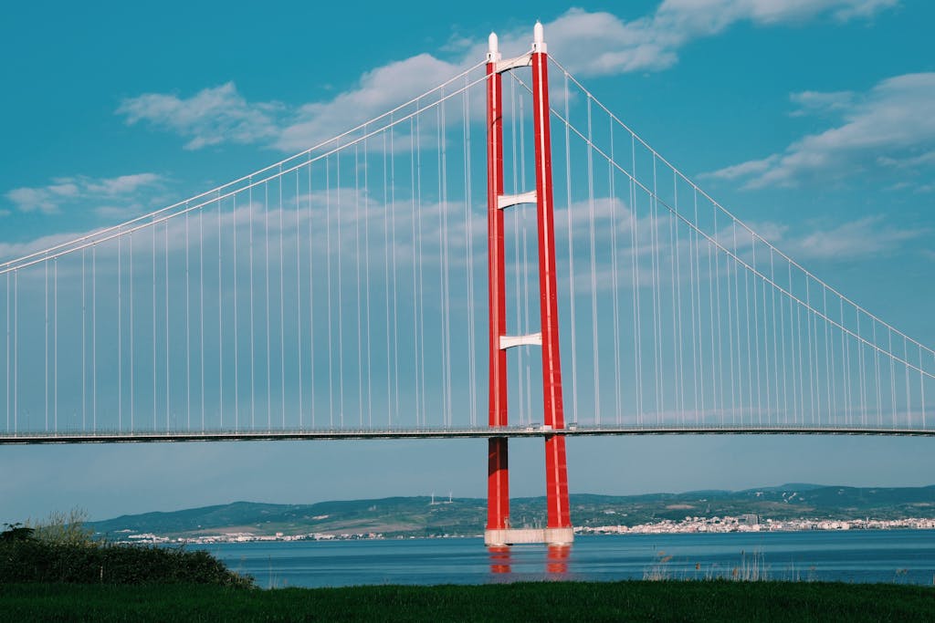 A captivating view of the Humber Bridge spanning across a calm river under a blue sky.